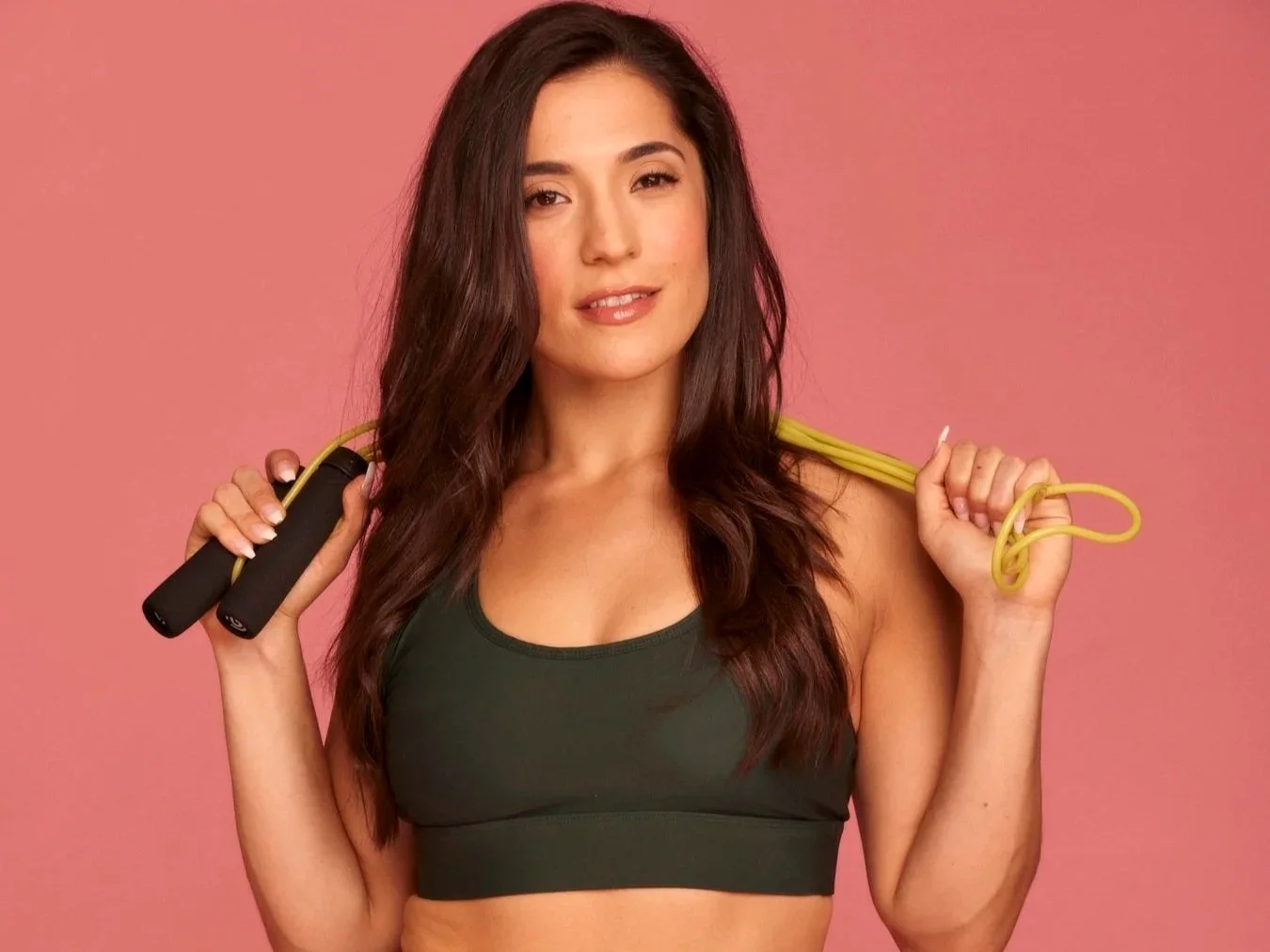 Shira Math holding a jump rope against a pink backdrop